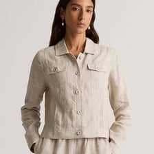 Flax plants beside linen fabric and a linen jacket.