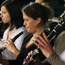 A musician checking an instrument’s tuning before playing
