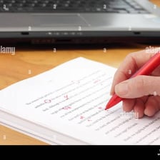 An editor proofreading a manuscript and marking small typographical corrections.