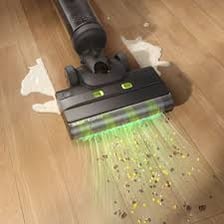 A round Roomba robotic vacuum cleaner cleaning a floor
