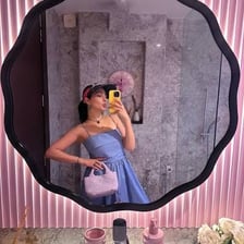A person taking a mirror selfie to show an outfit