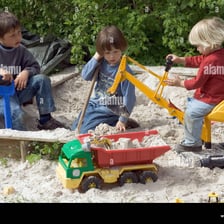 A young child playing in a sandbox.