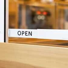 An open sign displayed on a shop door.