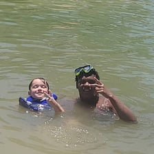 A person briefly entering a lake for a swim