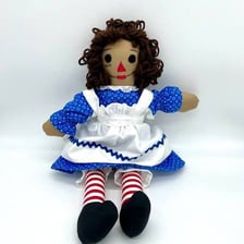 A Raggedy Ann cloth doll with red yarn hair