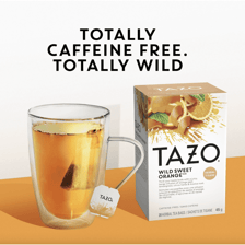 A Tazo tea package beside a cup of brewed tea.