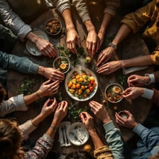 People beginning to eat a meal around a dinner table