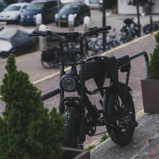 Two battery-powered electric bicycles parked outdoors.