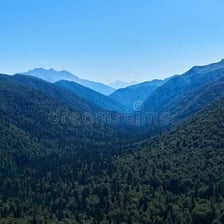 A narrow, secluded valley surrounded by wooded hills