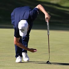 A golfer putting on a golf green.