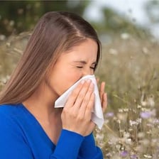 A person sneezing during pollen season.