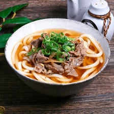 A bowl of thick udon noodles in broth