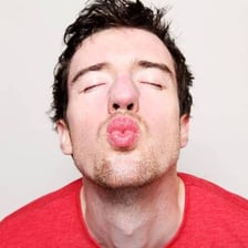 A person puckering their lips as if to blow a kiss.
