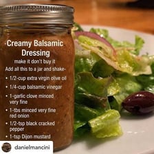 A bottle of extra-virgin olive oil beside vinaigrette ingredients.