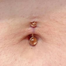 A close-up view of a navel with a piercing