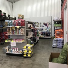 A pet-store aisle displaying dog toys, bowls, and leashes.