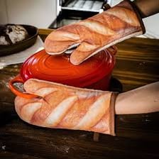 Heat-resistant oven mitts beside baked goods