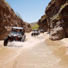 An all-terrain vehicle traveling on an unpaved trail