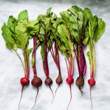 Several dark red beets with leafy stems