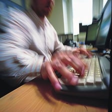 A person typing quickly to finish a report