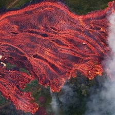 Red lava flowing from an erupting volcano