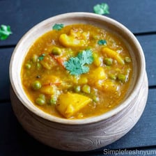 A bowl of aloo matar containing peas and potatoes