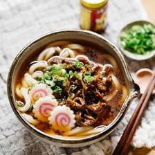 A bowl of thick Japanese udon noodles in broth.