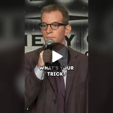 A comedian delivering a dry, deadpan expression.