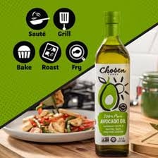 Bottle of avocado oil beside whole and cut avocados