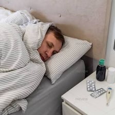 A person resting while ill with cold symptoms.