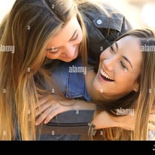 Friends laughing together during a playful conversation.