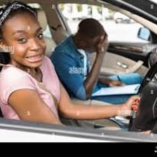 A driving-school student learning behind the wheel with an instructor
