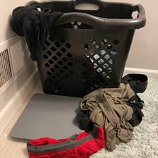 Soiled clothing piled in a laundry hamper