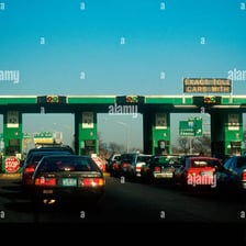 Cars passing through a highway toll plaza.