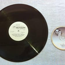 A vinyl LP record displayed beside a compact disc.