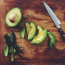 A halved avocado with its pit and green flesh visible.
