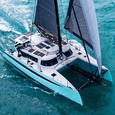 A catamaran traveling under sail.