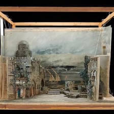 A theater stage with designed scenery and set pieces.