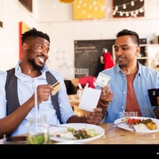 A diner offering to pay a restaurant bill for the group.