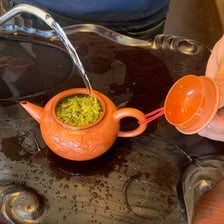 Tea leaves steeping in hot water inside a teapot