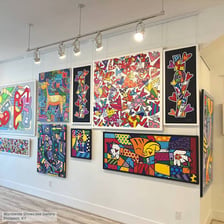 Framed paintings displayed on the walls of a museum gallery