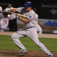 A baseball batter making a bunt near home plate.