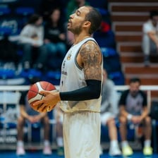 A basketball player holding a ball on a basketball court