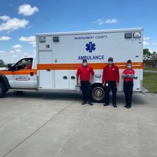 An emergency medical technician beside an ambulance.