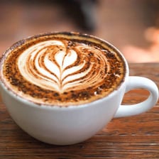 A cup of mocha latte topped with foamed milk.