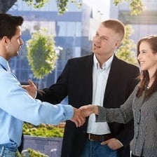 People beginning a conversation around a meeting table.