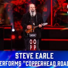 Steve Earle performing with a guitar.