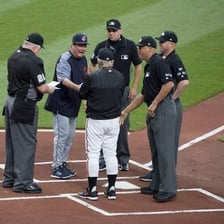 Baseball umpires positioned on a playing field.