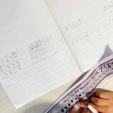 A person working an addition problem on paper.