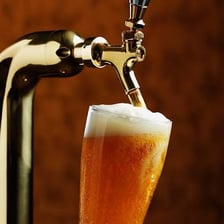 Beer being poured from a tap into a glass.